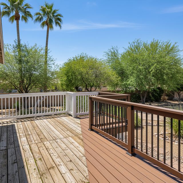 A deck with white and dark metal picket railings